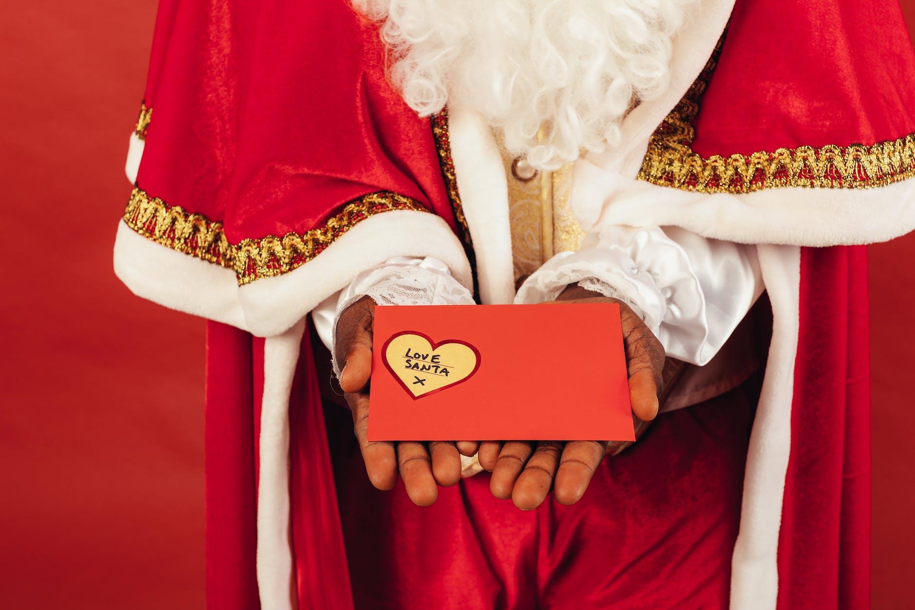 person wearing santa claus outfit while holding christmas letter